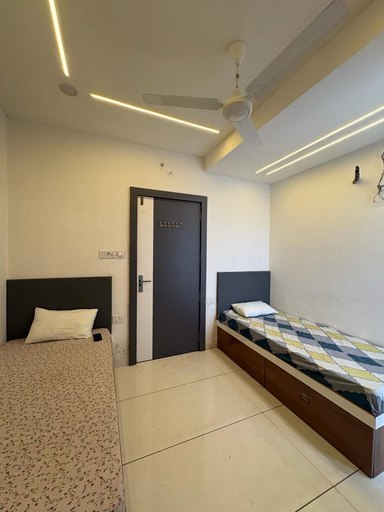 Furnished room with two beds and wooden wardrobe